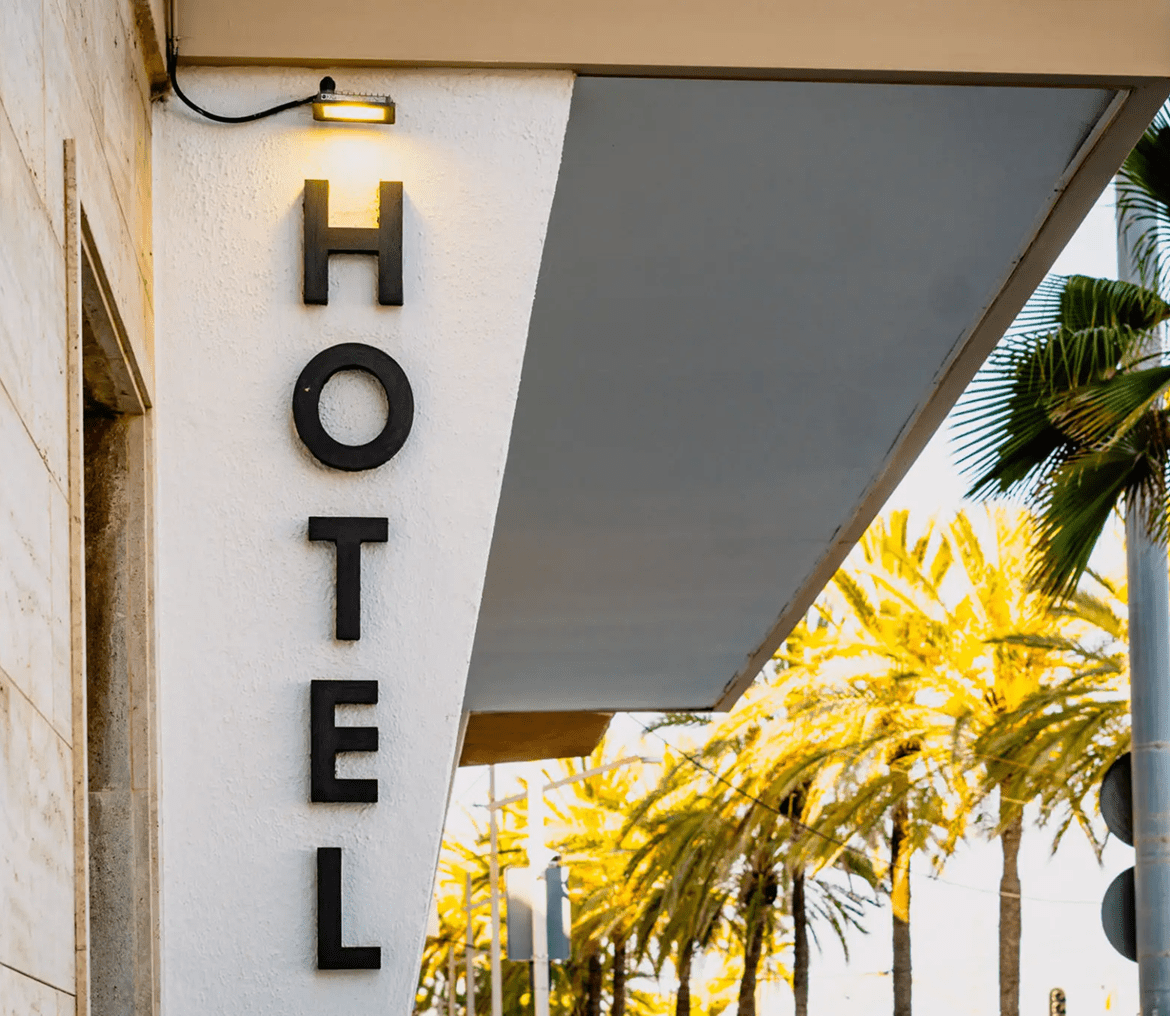 Hotel sign with palm trees in background.